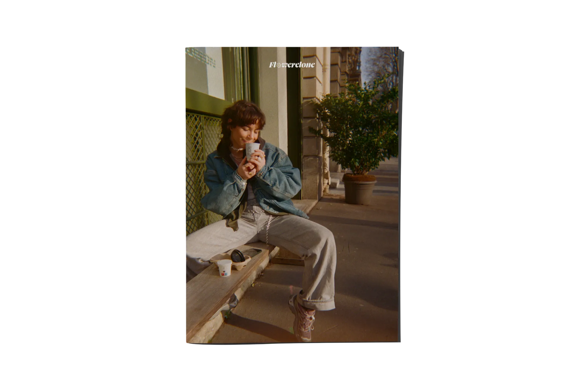 Flowerelone fanzine cover: a woman sitting on a bench, coffee in hand.