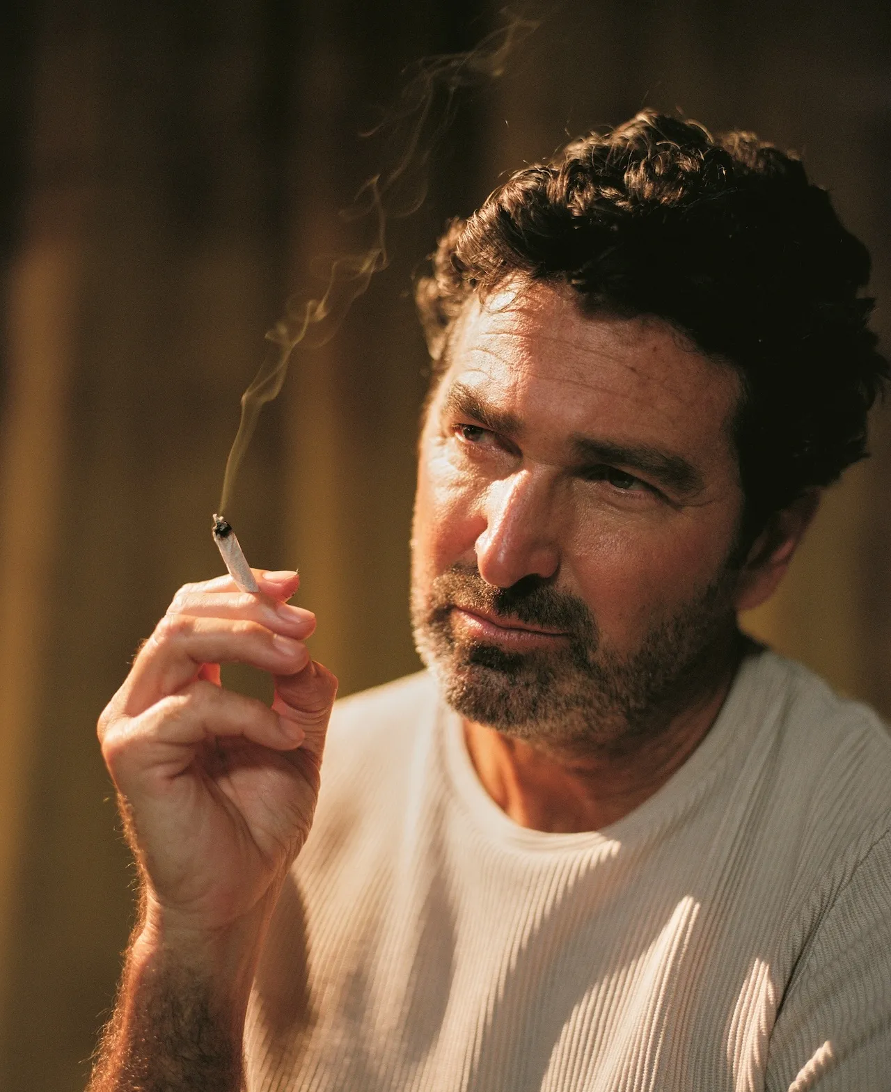 Portrait of a man holding a lit cigarette