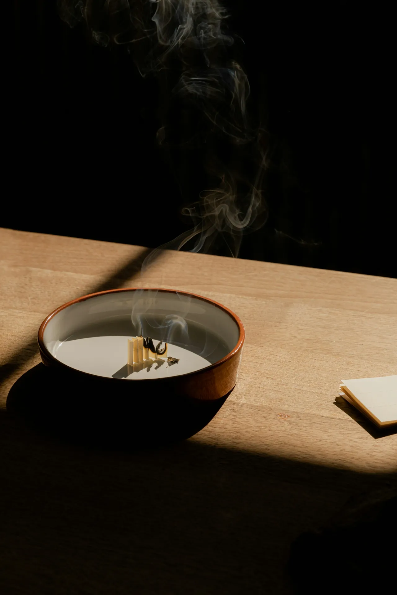Smoking bowl on a wooden table in raking light